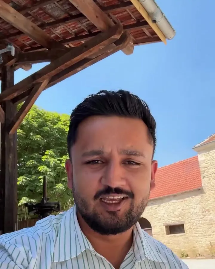 Shawez Ali sur le terrain devant une maison en pierre